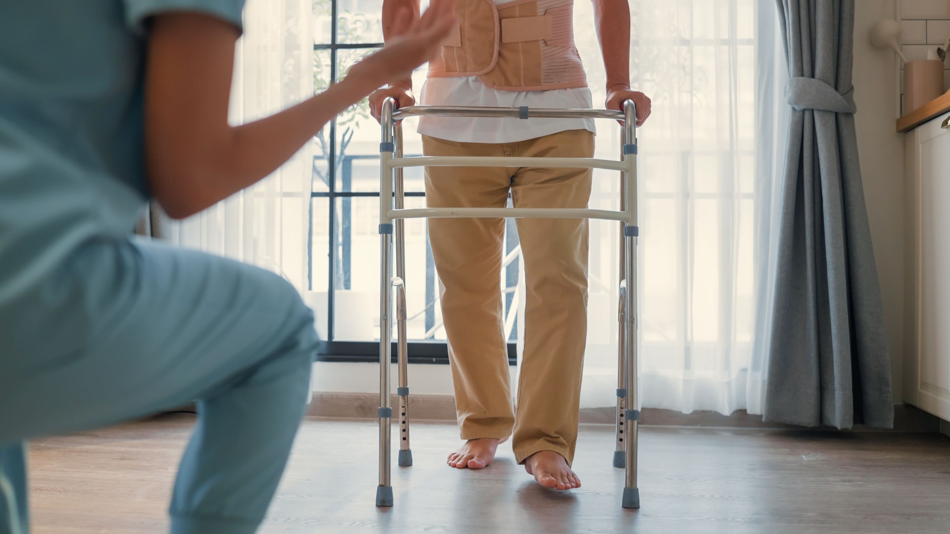 Asian Caregiver nurse  Physiotherapist instructor cheer up encourage patient senior man use walker walking in living room at home, A professional nurse physical therapy and healthcare with exercise for rehabilitation, medical and insurance