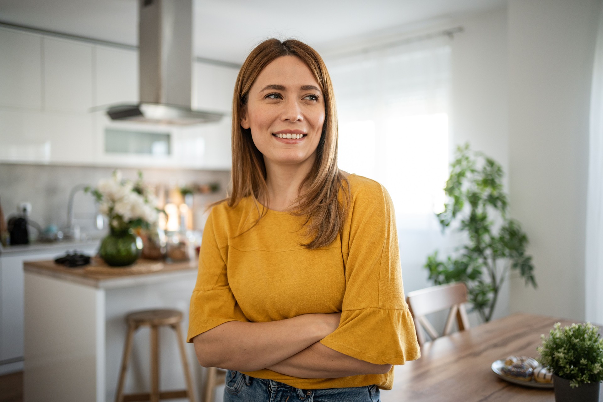 Portrait of a beautiful woman standing in the living room, confident, strong and smiling